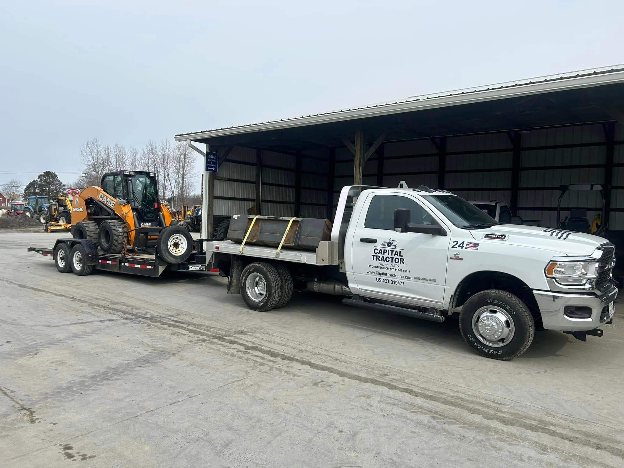 Capital Tractor, Inc pickup and trailer pulling a sv340 case skid steer and bucket attachment.